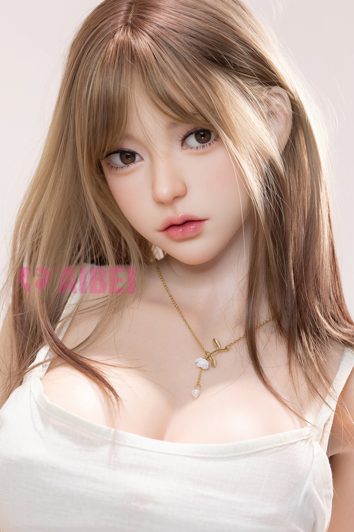 Front-facing portrait of the Aibei Doll Lillian, 167 cm E-cup silicone model, with shoulder-length light brown hair, wearing a white satin camisole and gold necklace.