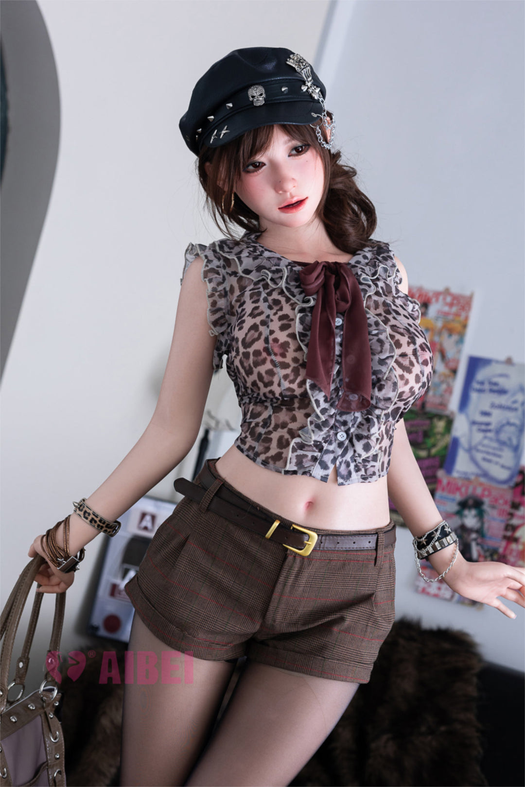 Aibei Doll 167cm E Luxe Silicone - Yuna V2 – Standing pose, black cap, animal-print corset top with layered accessories, wavy auburn hair falling forward, graffiti-covered backdrop.