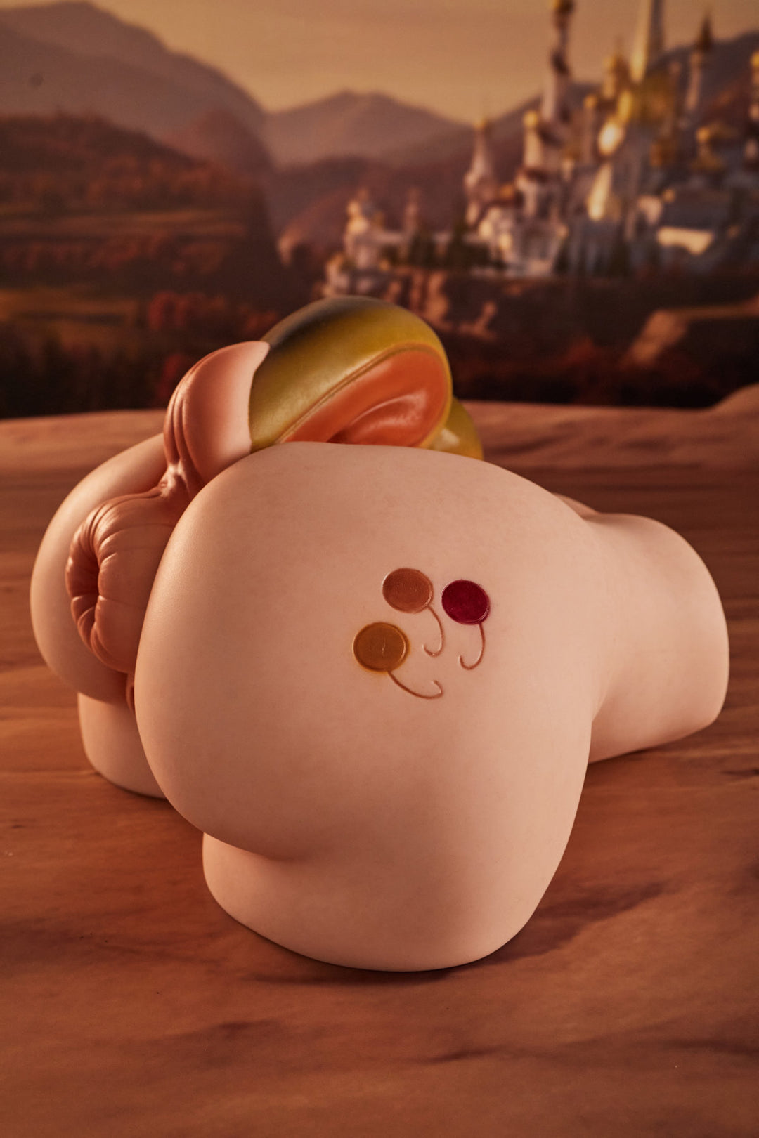 CLIMAX DOLL - PA-Peppy Silicone Butt Torso (Cinnamon) rear three-quarter view with yellow horn accessory detail, desert ruins background

