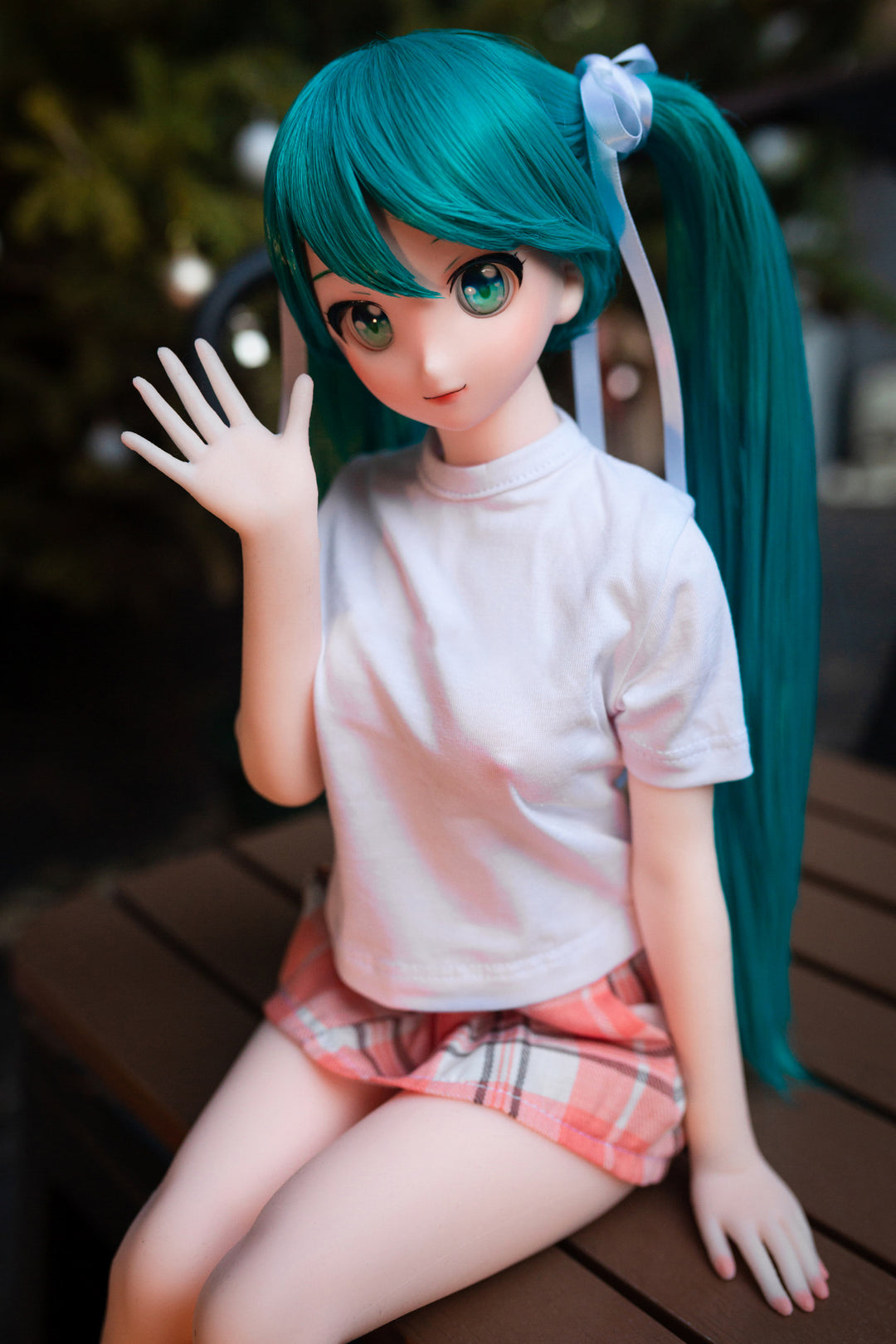CLIMAX DOLL Mini J60 cm Hybrid - Miku (Cinnamon) - Close-up with one hand raised in a friendly wave, teal twin tails, bright aqua eyes and a sweet smile, dark night backdrop.