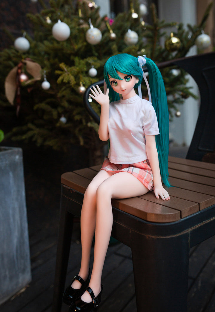 CLIMAX DOLL Mini J60 cm Hybrid - Miku (Cinnamon) - Full-body seated pose with legs dangling and black shoes, teal twin tails, white tee, plaid skirt, fairy-lit tree glowing behind.