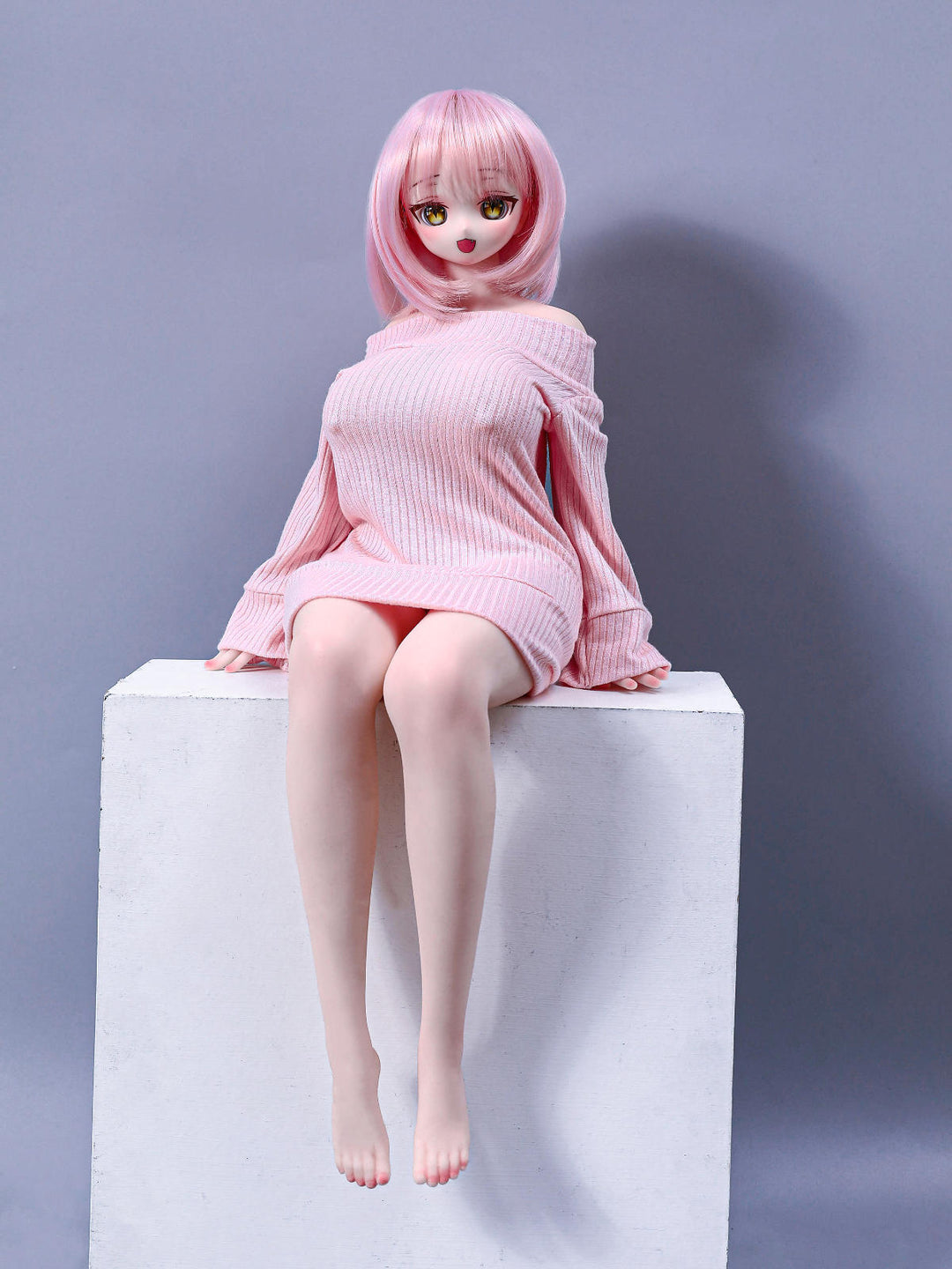 CLIMAX DOLL Mini J60cm P Hybrid - Azami (Cinnamon) seated pose on a white cube with knees together, pale pink knit sweater dress, lavender-gray backdrop