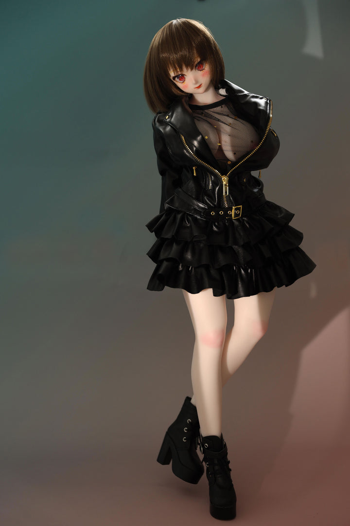 CLIMAX DOLL Mini J60cm P Hybrid - Zella (White) - Full-body standing pose in a glossy black ruffled jacket over a sheer black top, with black boots, short brown bob, teal-green backdrop.