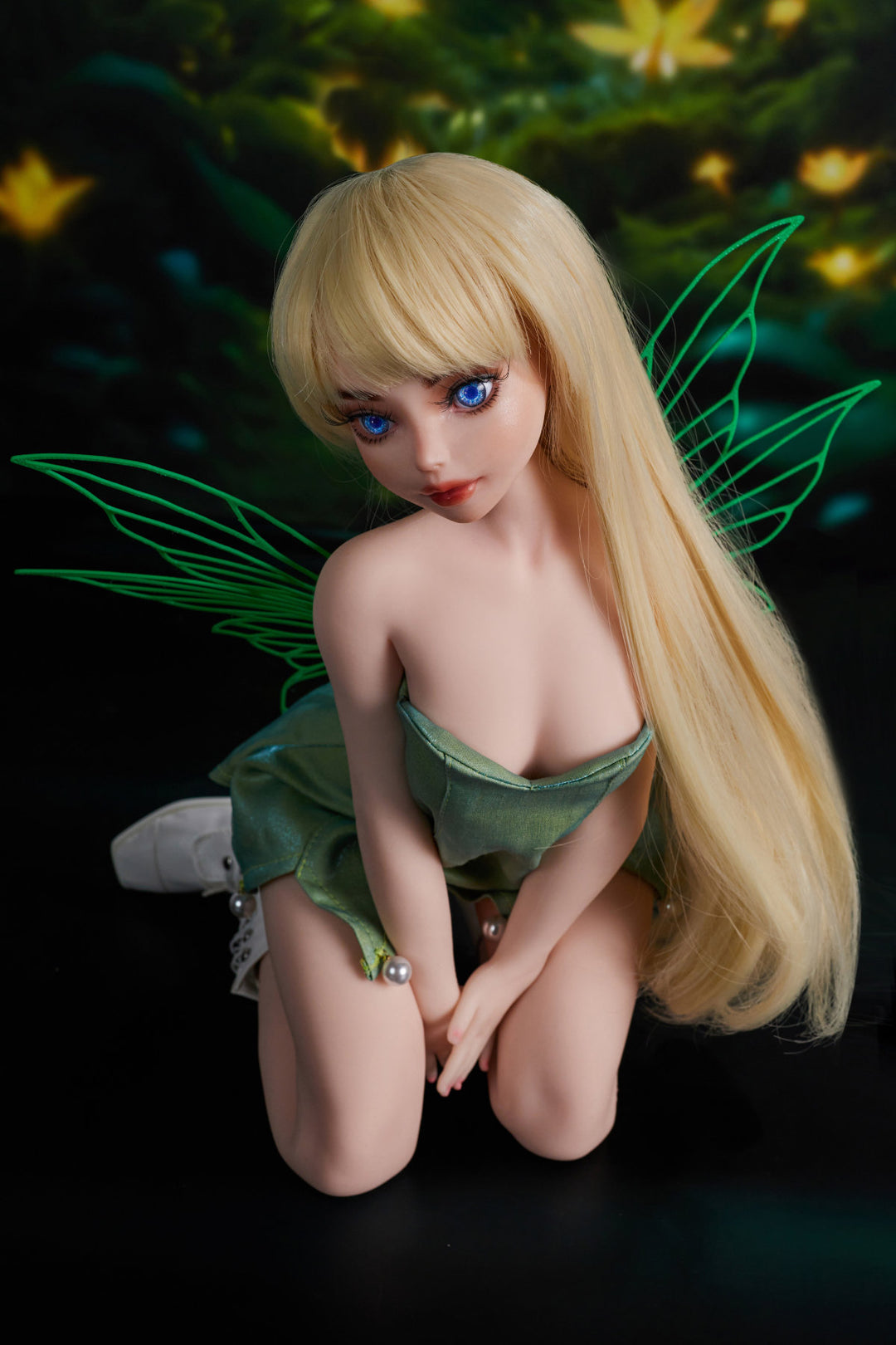 CLIMAX DOLL Mini Si60 cm XS Silicone - Holly (Cinnamon) full body kneeling pose in green strapless mini dress with white boots, short blonde hair, enchanted forest background
