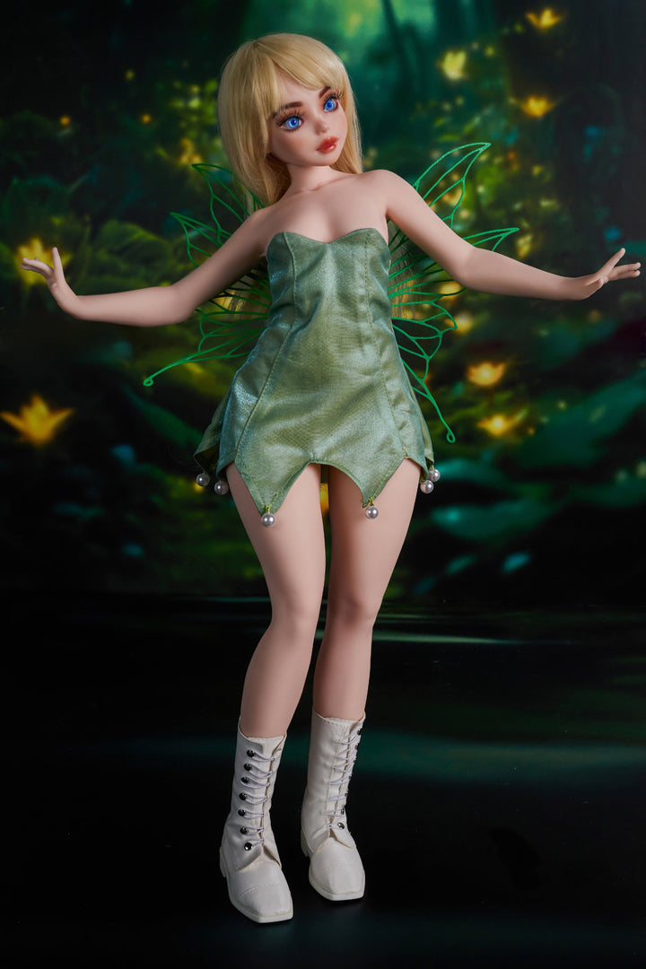 CLIMAX DOLL Mini Si60 cm XS Silicone - Holly (Cinnamon) full body side view in green strapless mini dress with white boots, short blonde hair, enchanted forest background
