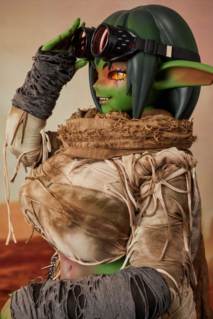 CLIMAX DOLL ULW SiF120 cm Silicone - Barza (Green) upper body front view in tattered tan wrap outfit, short green hair, desert red background
