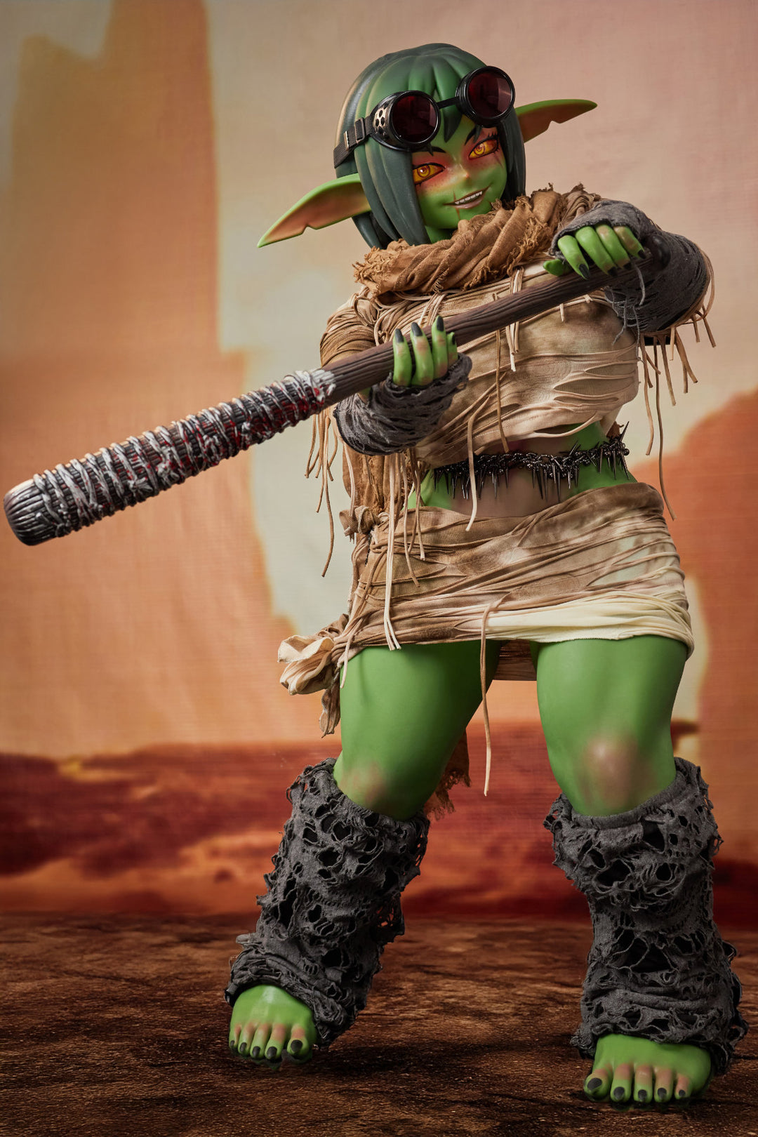 CLIMAX DOLL ULW SiF120 cm Silicone - Barza (Green) full body side view in tattered tan wrap outfit, short green hair, desert red background
