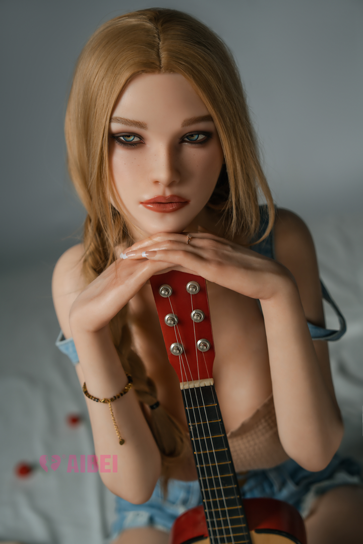 Aibei Doll 158 cm F Silicone - Aria V3 with long blonde hair holding a small red guitar, sitting upright against a neutral background.