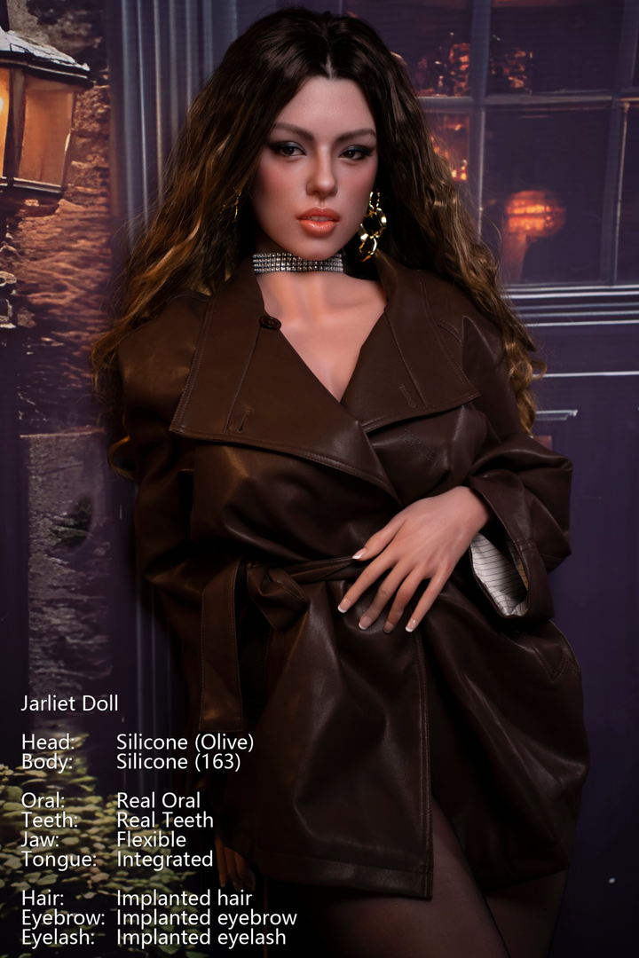 A close-up of Jarliet Doll 163 cm D Silicone - Olive V2, showcasing her facial details and auburn hair styled up, wearing gold earrings and a brown leather jacket.