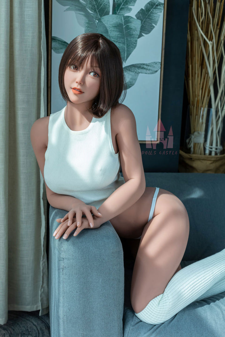 Dolls Castle® 163 cm E TPE - #K3 full body standing front view in white sleeveless top and white shorts, short brown bob hair, teal indoor background
