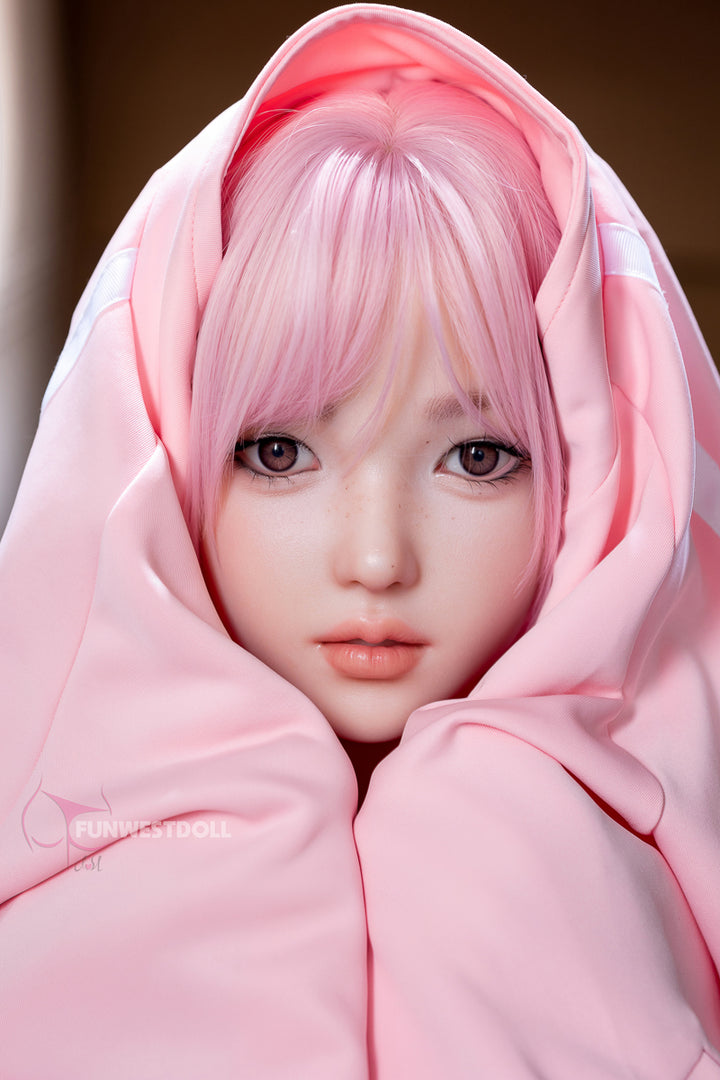 Close-up of FunWest Doll 152 cm D Silicone – Anime Nika, with pink anime-style hair and large eyes, wrapped in a soft pink hoodie blanket.