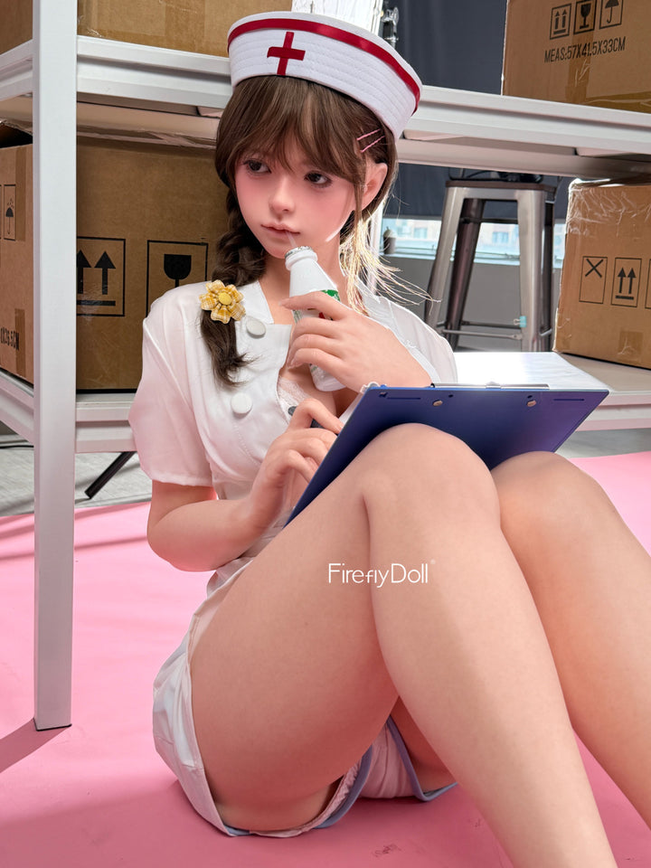 Firefly Diary Doll 159 cm Silicone - Liu Li V4 seated in her nurse cap holding a small device, pink shorts and white uniform top
