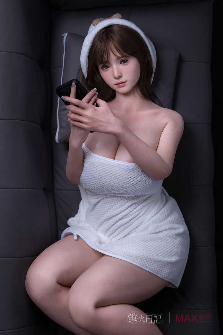 Firefly Diary Doll 160 cm Max Series Silicone - Little Leeson wrapped in a towel using a smartphone.