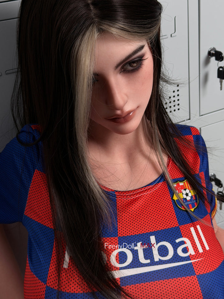 Firefly Diary Doll 160 cm G Max Series Silicone - Rona seated in her football jersey, holding a soccer ball on her lap, white lockers behind her