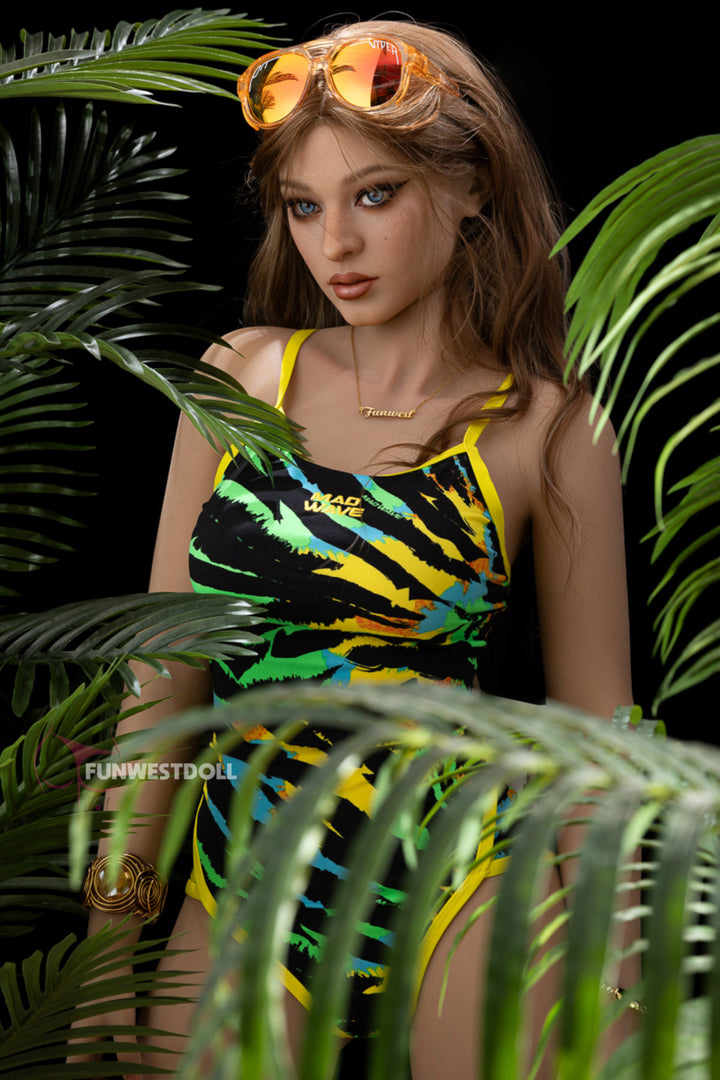 FunWest Doll 159cm F TPE - Sheila upper body front view in yellow green tropical swimsuit with sunglasses on head, highlighting realistic F-cup chest detail against dark background
