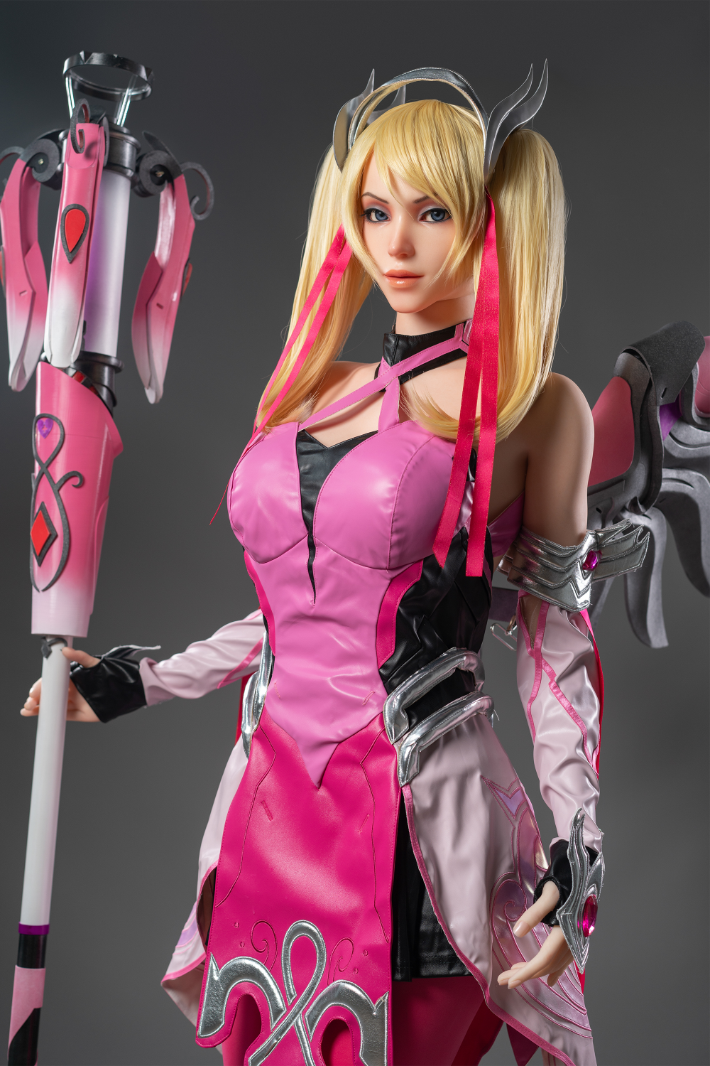 Game Lady 171 cm G Silicone - Mercy in a pink and black outfit with a weapon on her hand.