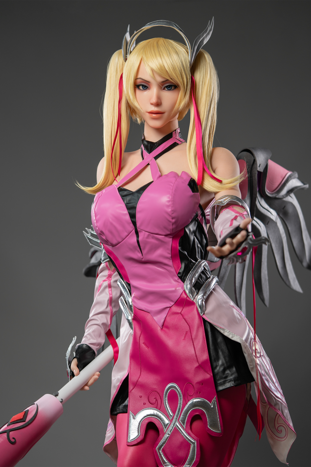 Game Lady 171 cm G Silicone - Mercy in pink and black outfit with wings on a gray background