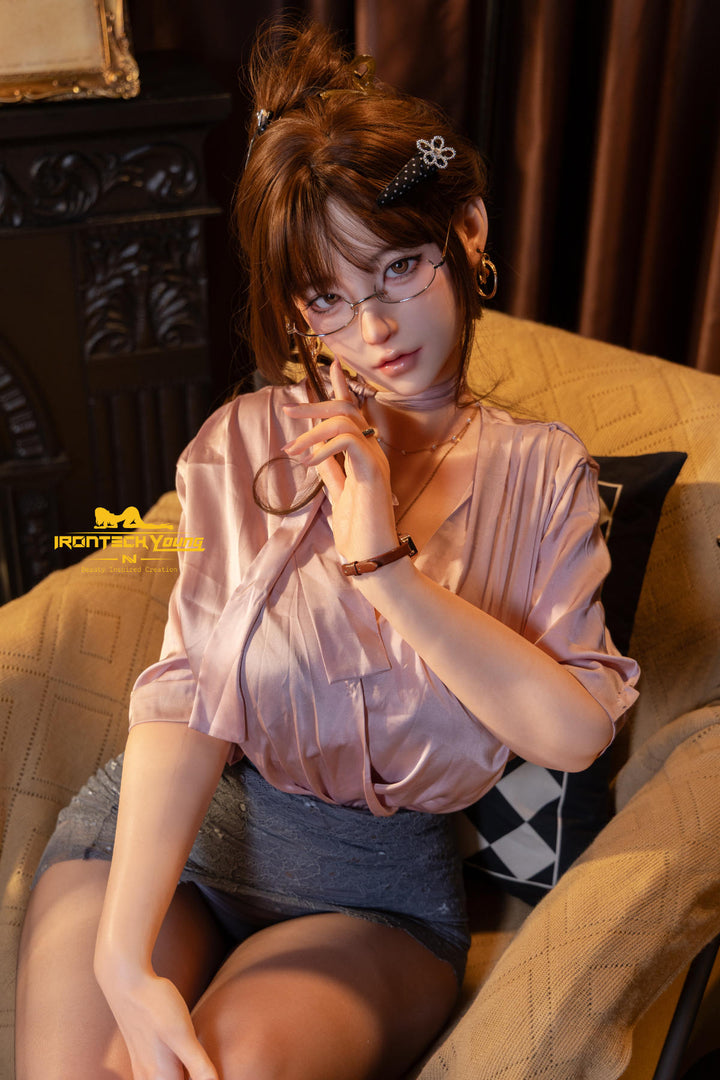 Irontech 165T E Young Series Silicone - Sia – chestnut hair in a loose bun, glasses and dusty-pink satin blouse, seated in a golden armchair