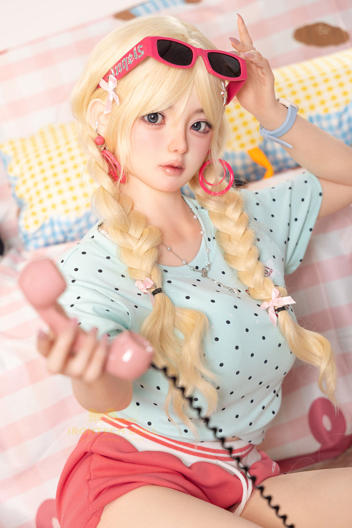 Irontech Doll 148 cm Plus B Silicone - Xia Ying seated pose in light blue polka dot crop jacket and pink bikini top with blonde twin buns, bright kawaii bedroom background