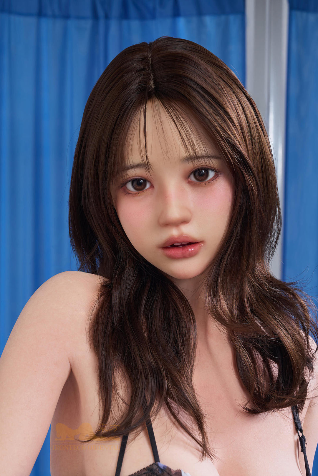 Close-up head and shoulders portrait of the Irontech Doll 151 cm D Oriental Series Silicone – Evie against a blue curtain backdrop.