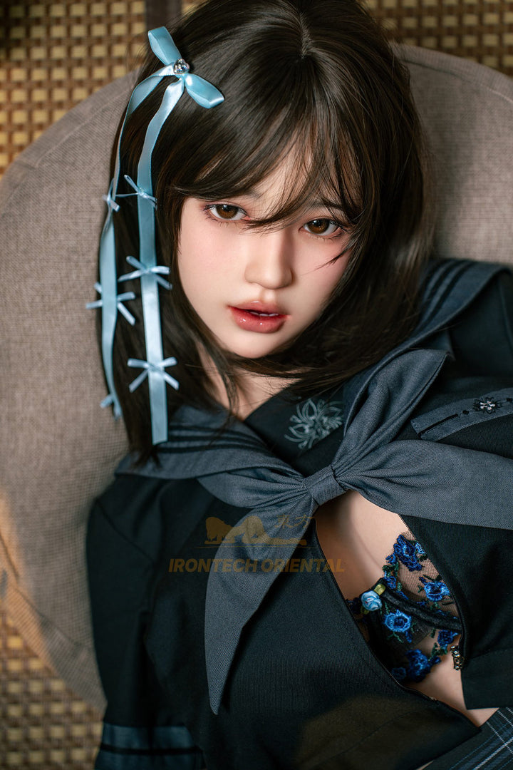 Irontech Doll 161cm F Oriental Series Silicone – Evie V4 – Seated pose holding a paper lantern prop, black kimono-style top, blue hair ribbons, dark braided hair, warm-lit traditional backdrop.