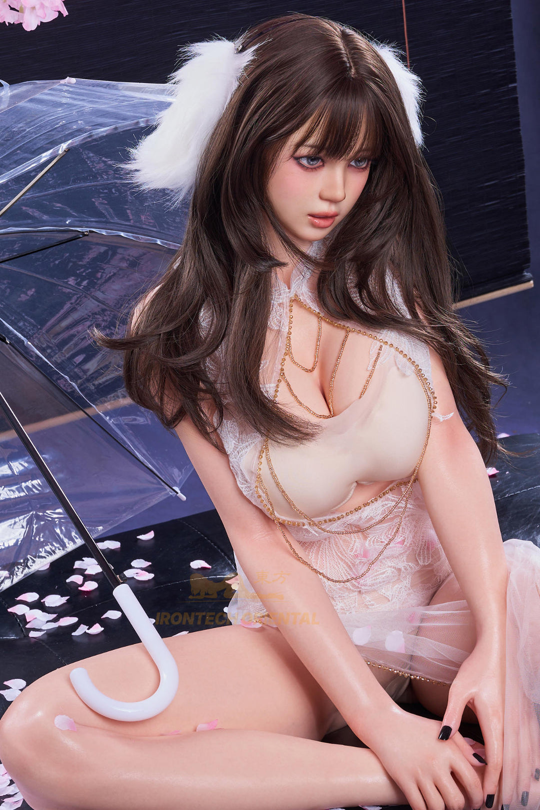 Irontech Doll 161 CM F Oriental Series Silicone - Nia V2 seated pose in sheer white outfit surrounded by cherry blossom scenery, three-quarter body view
