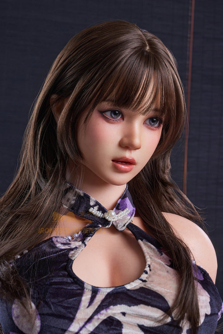 Irontech Doll 161 CM F Oriental Series Silicone - Nia V3 close-up upper body view wearing blue floral Chinese qipao dress with purple robe, showcasing realistic oriental facial features with long dark wavy hair against dark background
