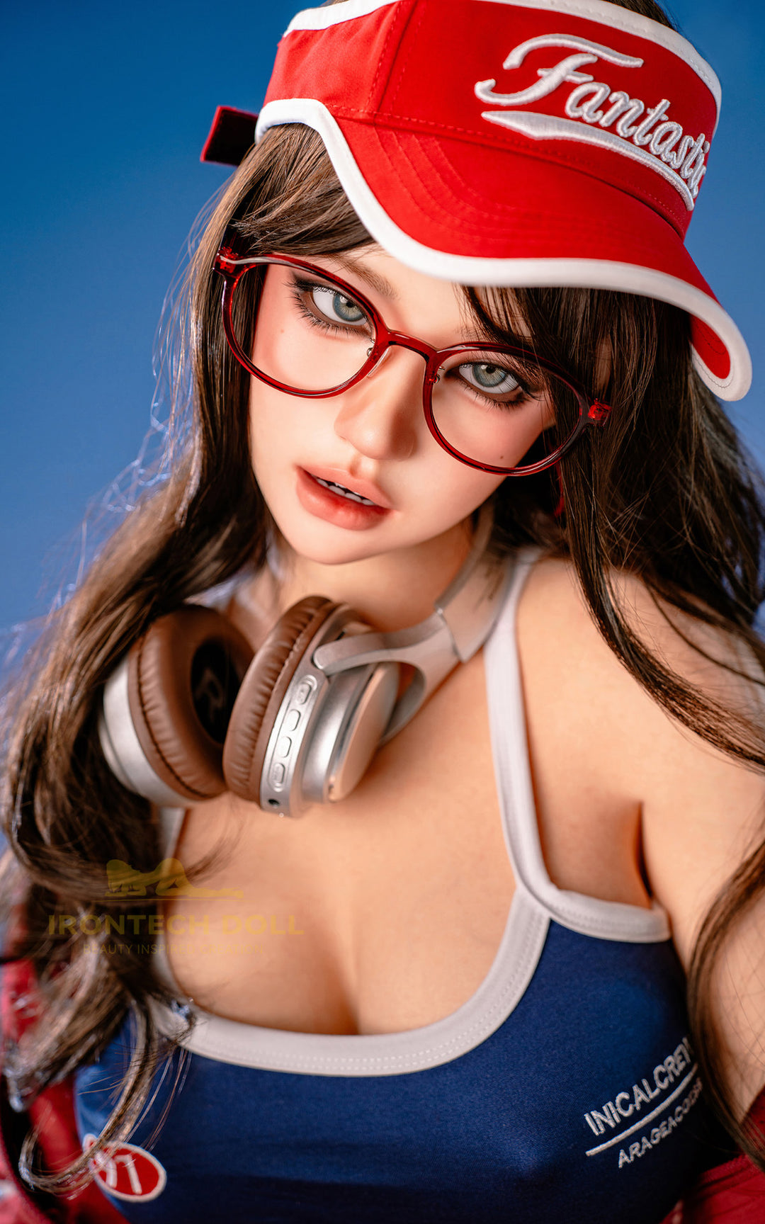 Irontech Doll 161 CM F Silicone - Evie upper body front view in red cap and blue crop top, highlighting realistic silicone skin texture with dark brown hair against bright blue background