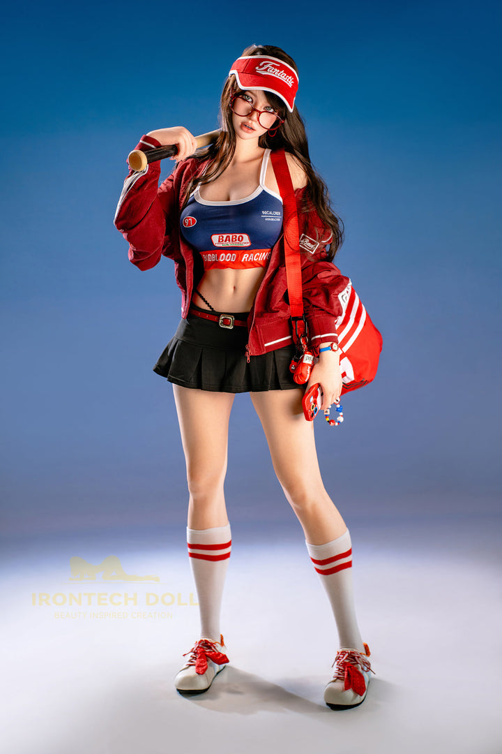 Irontech Doll 161 CM F Silicone - Evie full body side view in red jacket draped over blue racing outfit, showcasing realistic silicone figure craftsmanship against blue studio background