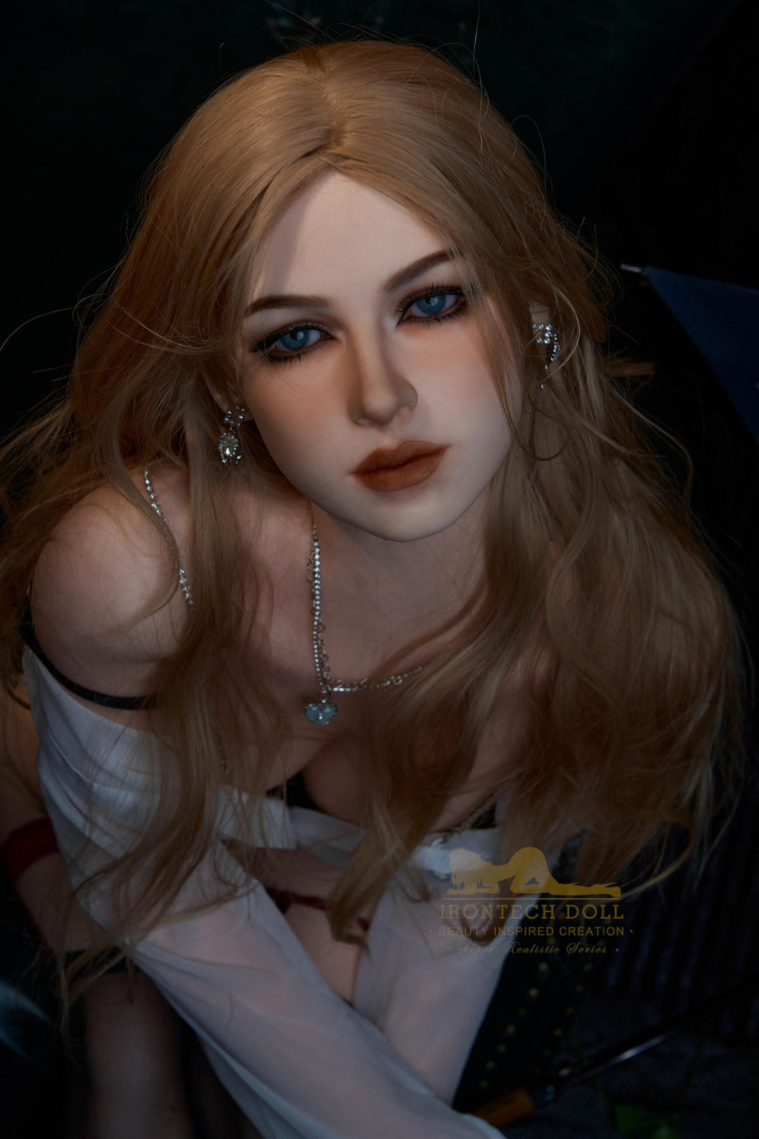 Close-up of Irontech Doll 164 cm E Silicone - Flora with blonde hair and blue eyes, wearing a white top.
