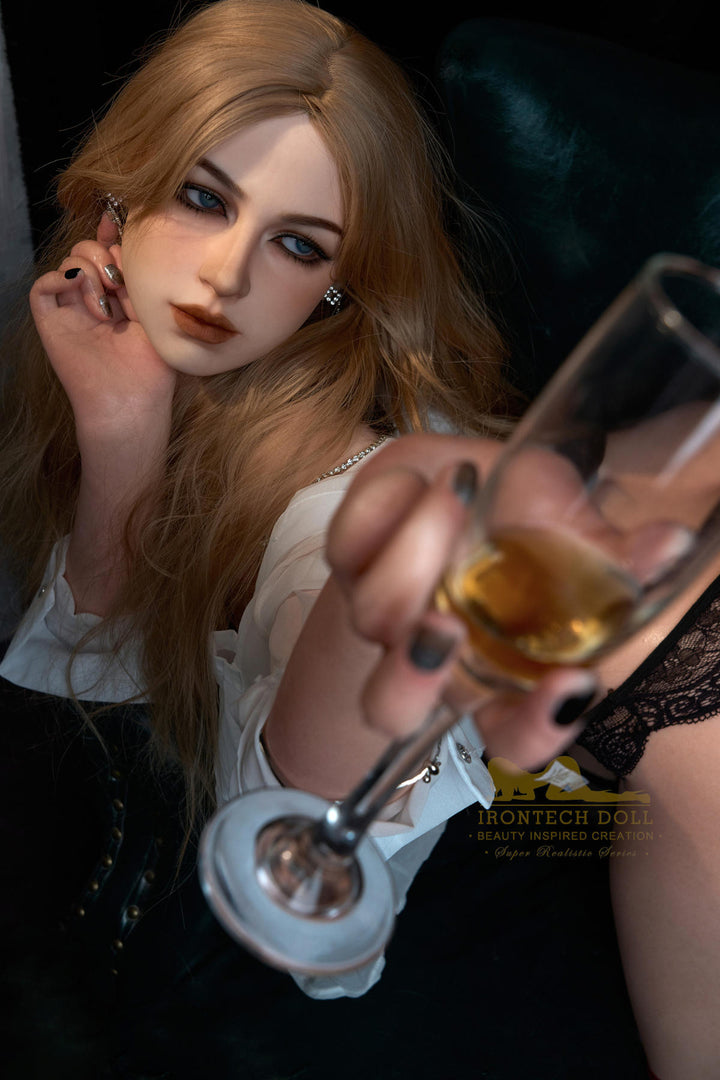 Irontech Doll 164 cm E Silicone - Flora holding a glass with a drink sitting in a chair.