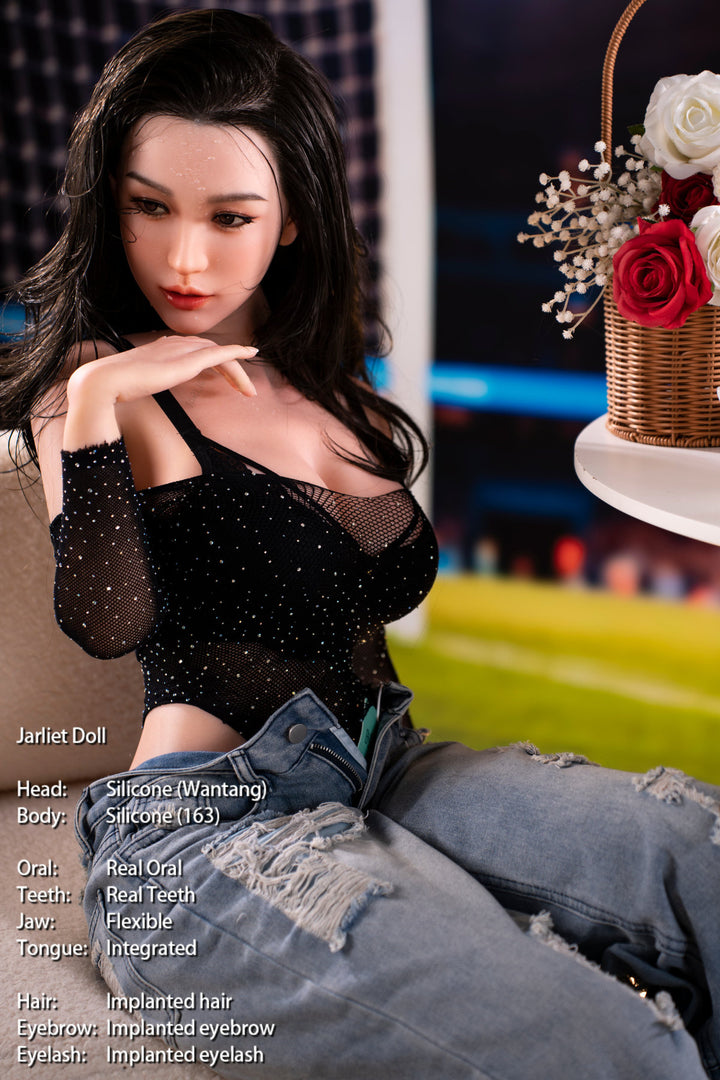 Jarliet Doll 163 cm D Silicone - Wantang seated with legs stretched out, black lace top and ripped denim, carnival lights behind her