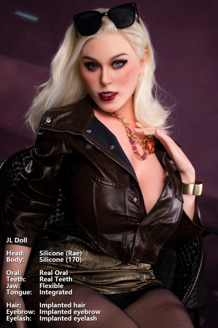 Jarliet Doll 170 cm G Silicone - Rae seated on wicker chair wearing leather jacket with sunglasses pushed up, against purple background.