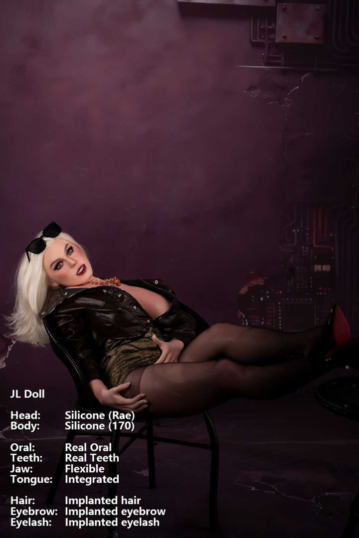 Jarliet Doll 170 cm G Silicone - Rae sitting on black chair against a dark purple industrial background, legs crossed, stockings and red heels.
