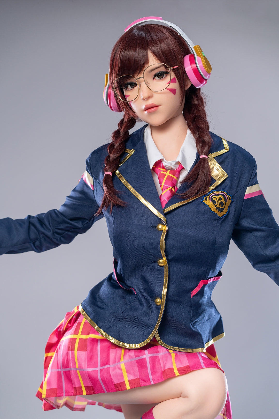 Game Lady 166 cm E Silicone – D.Va sitting while posing confidently, wearing a blue jacket and pink plaid skirt, showcasing her realistic silicone body and anime-inspired look.