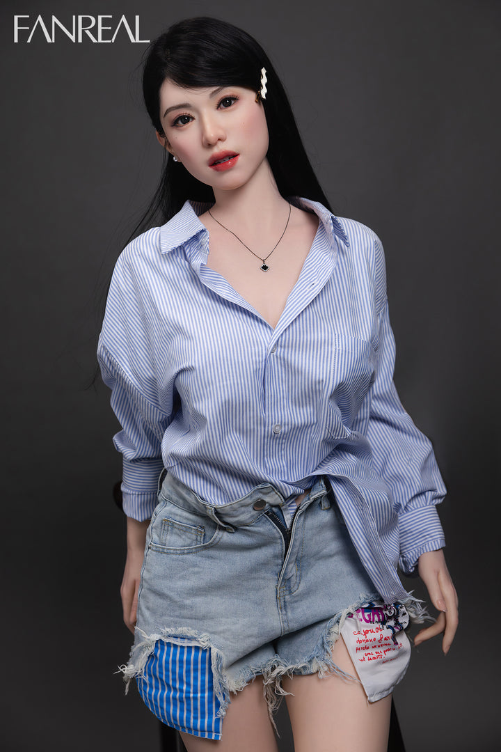 Fanreal 155cm silicone doll Kimmy wearing blue shirt sitting on bed