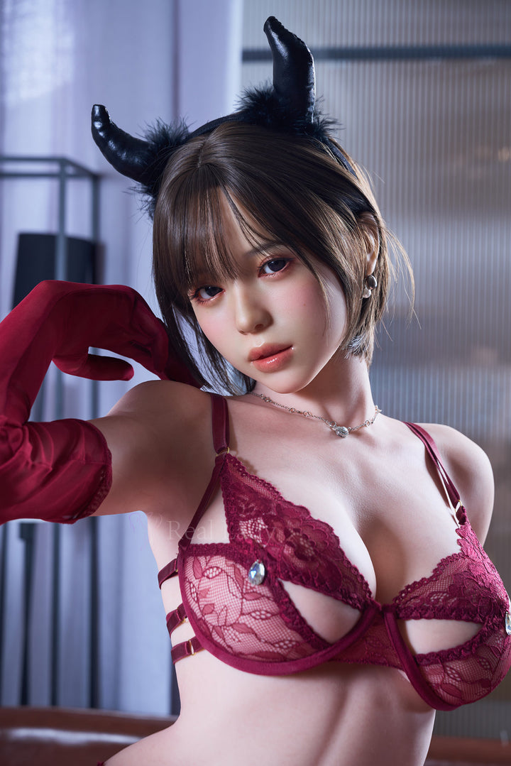 RealLady 159cm H Silicone - Alara – Seated pose leaning forward, black horns headpiece, red lace lingerie, sheer gloves, dark bob hairstyle, indoor backdrop.