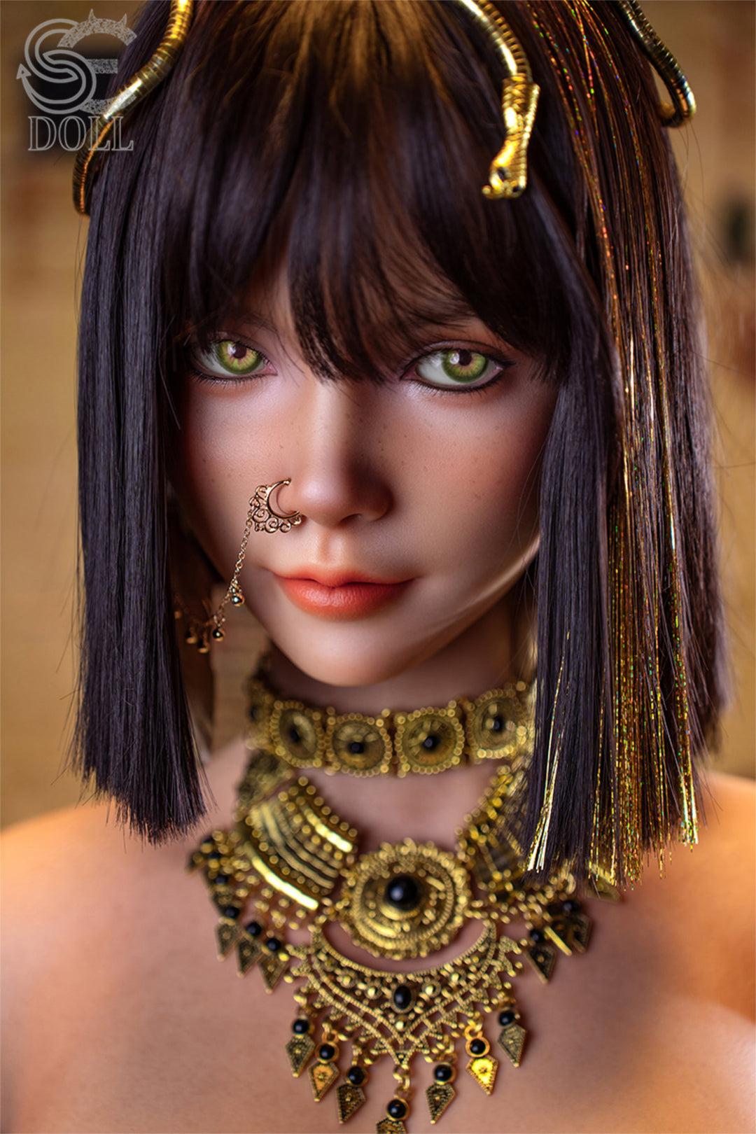 SEDOLL T111 cm G Silicone Torso - Kemeny.C upper body front view in gold Egyptian-style collar necklace and black strappy harness, short dark hair with gold braided accessories, warm temple background
