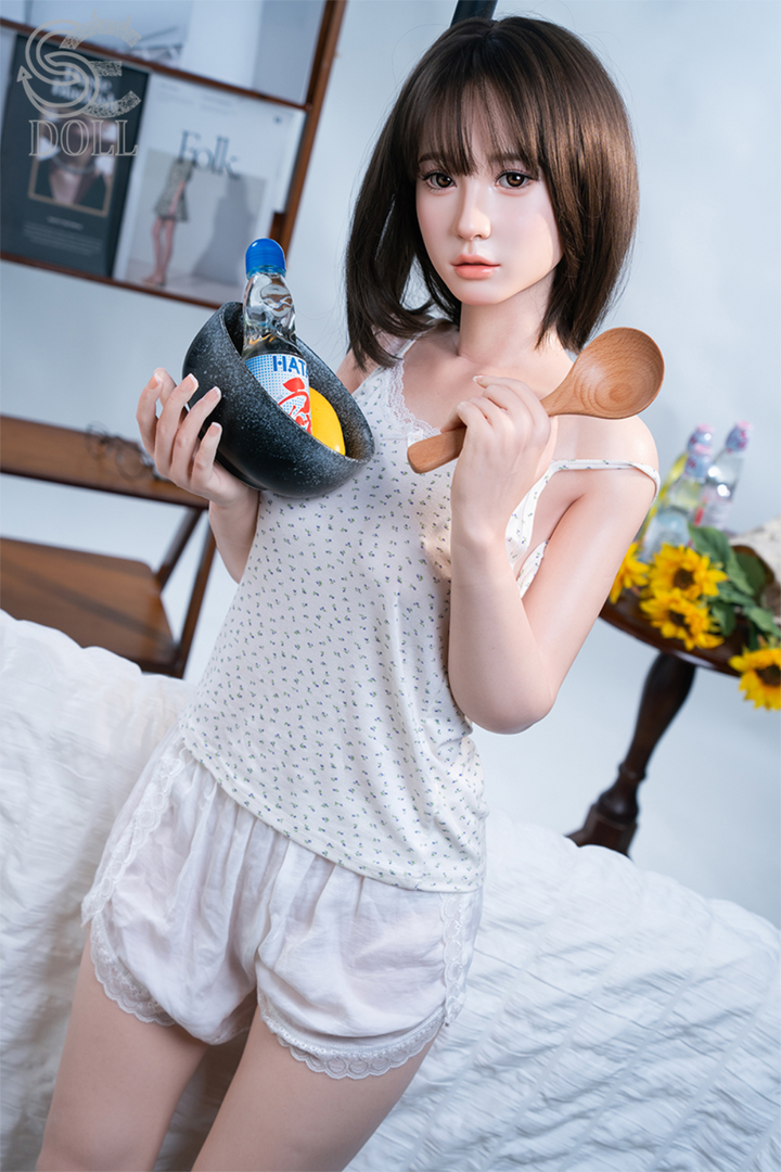 SEDOLL T153 cm A Aya Series Silicone -  Hinata.A V2 holding a spoon and a bottle of water in a room setting.