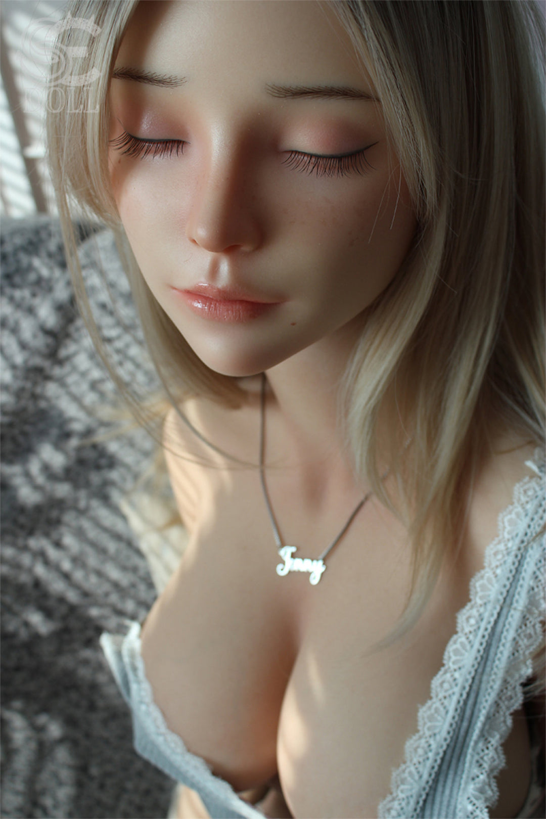 SEDOLL T161cm C Silicone Pro - Jenny.O – Close-up pose, light blue plaid top pulled down at the chest, wavy blonde hair framing the face, soft neutral backdrop.