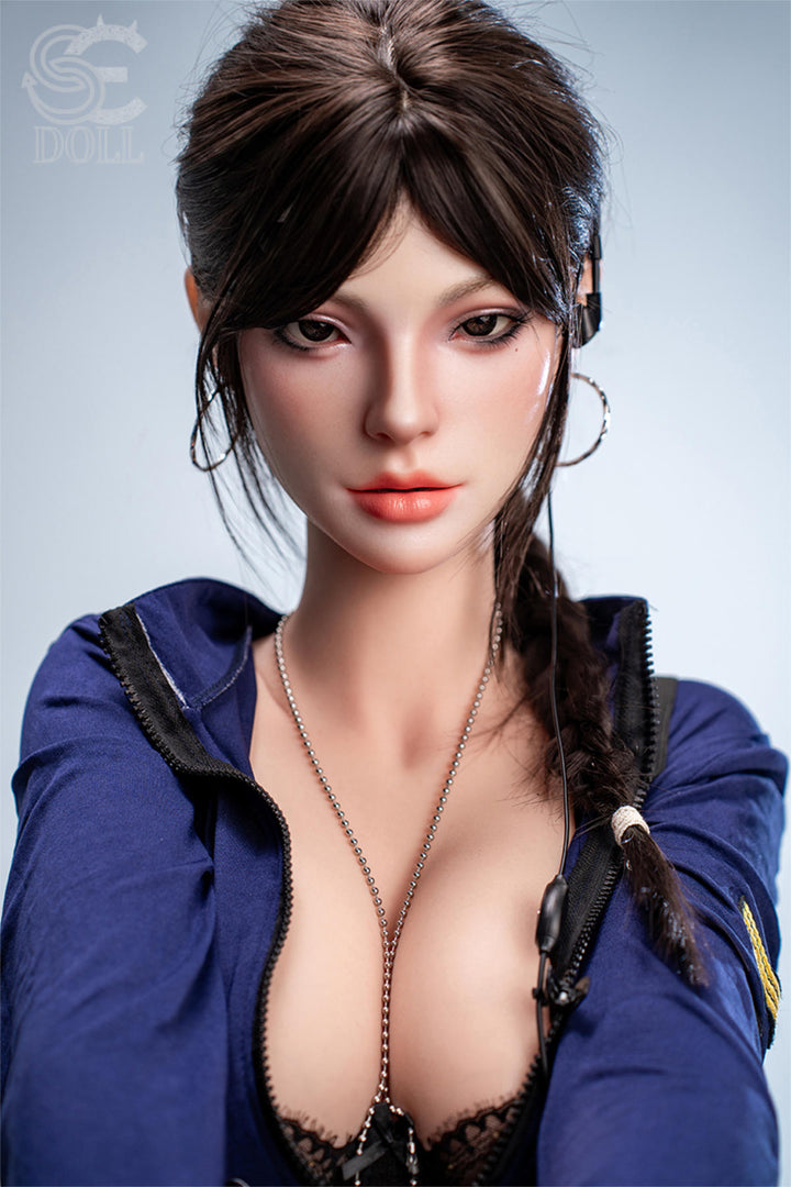 SEDOLL T161 cm C Silicone Pro - Nadia Voss.B close-up torso shot with her blue denim shirt open, dark hair in a loose braid, plain white backdrop