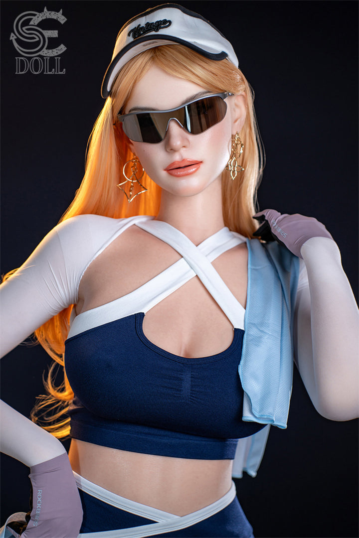 SEDOLL T175 cm E Silicone Pro - Nora.A standing in sunglasses with arm raised, holding the helmet aloft, navy harness top