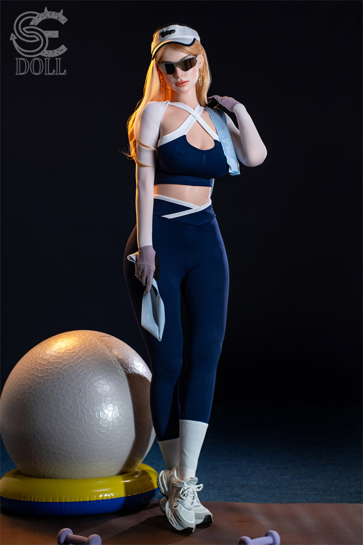 SEDOLL T175 cm E Silicone Pro - Nora.A standing beside a sci-fi sphere prop and helmet, navy outfit, dark studio setting