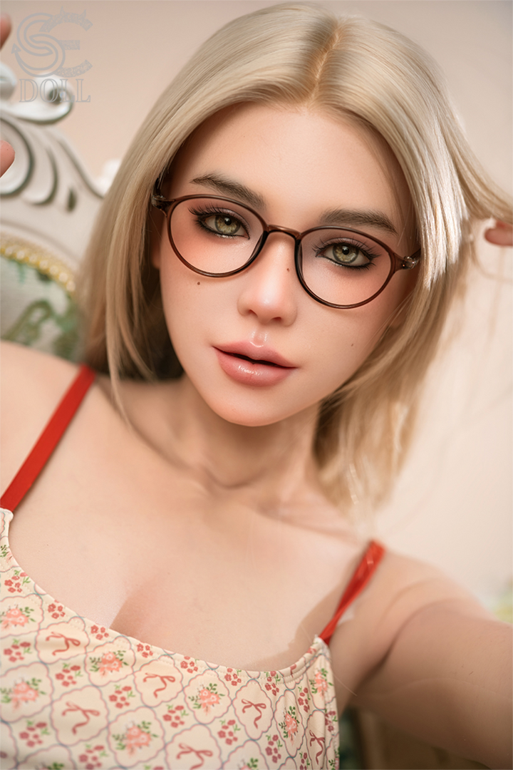 Close-up portrait of the SEDOLL 170 cm C Ultra Light Silicone - Maggie.D, focusing on her realistic facial features, round glasses, and blonde hair.