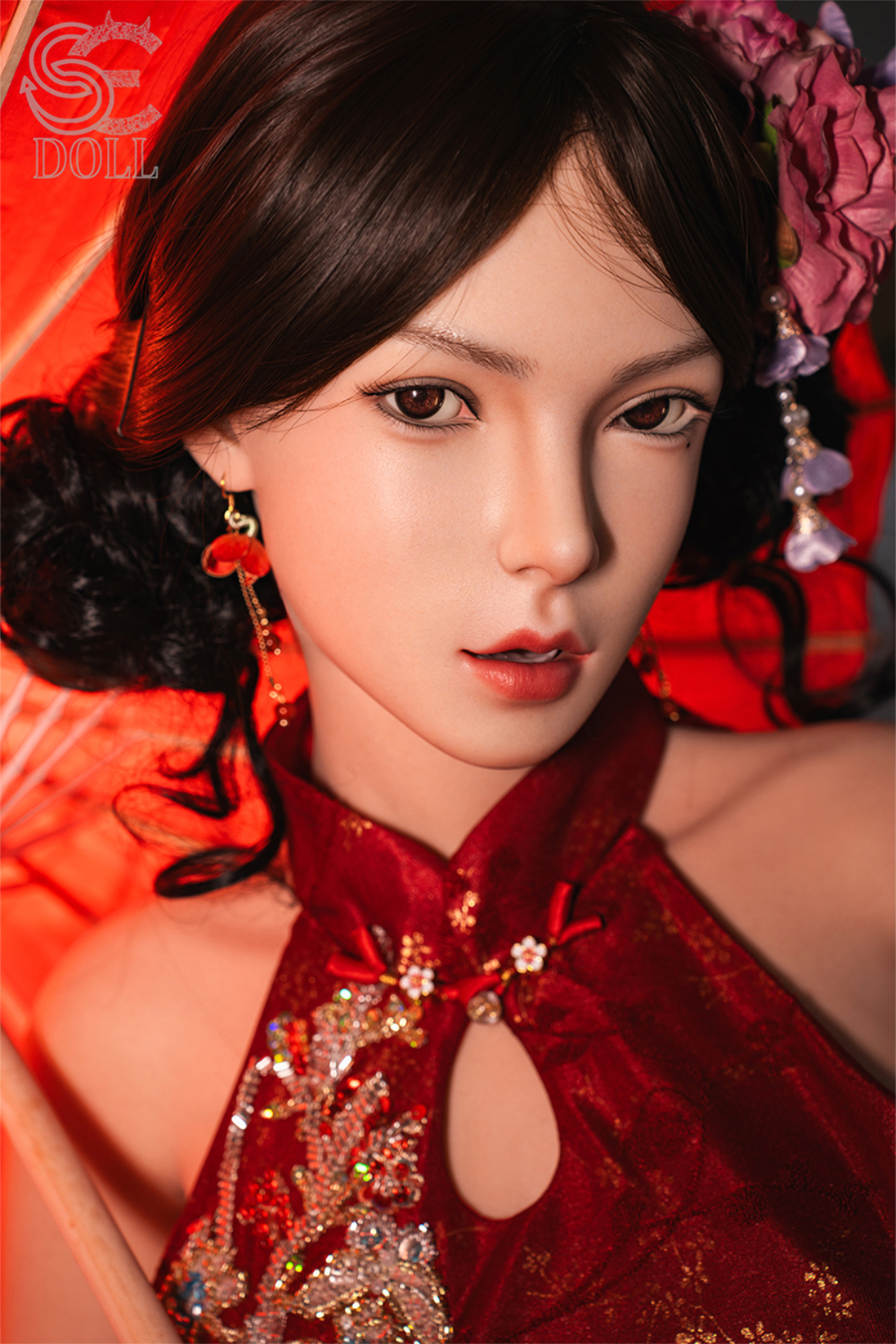 Close-up portrait of the SE DOLL T165 cm C Silicone Pro - Lumi.B, featuring a detailed face with dark eyes, dark hair styled with a flower, and a red sequined dress.