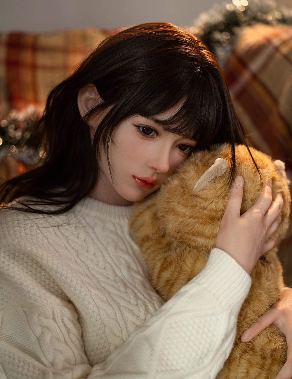 Close-up of the TOP-CYDOLL 162 cm E-Cup Sato Asuka with a soft, pensive expression, gently hugging a ginger teddy cat.