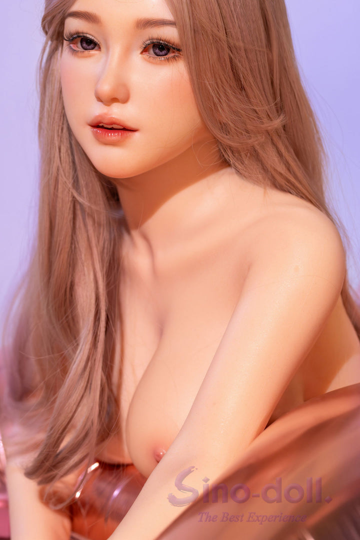 Naked Sino Doll Pro Soft Max 161 cm Platinum Silicone - Linchun (R+S Effect) with long blonde hair sitting in a chair.