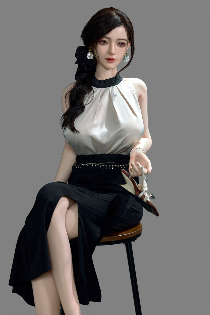 Starpery 171cm D - Asuka Eva – Seated pose on chair, cream halter top with black skirt, dark hair in half-up style, plain grey backdrop.