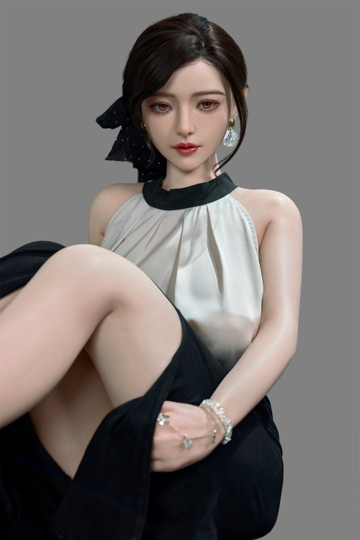 Starpery 171cm D - Asuka Eva – Seated pose on chair, cream halter top with black skirt, dark hair in half-up style, plain grey backdrop.