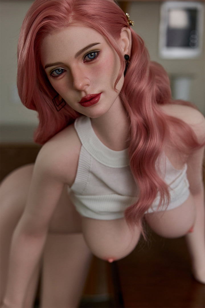 Starpery 171cm D - Benneth – Seated pose, pink wavy hair, mesh top pulled up exposing chest, indoor backdrop.